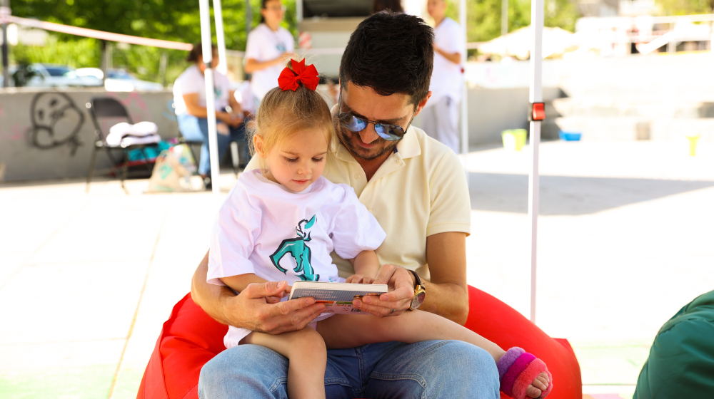 Father reading a book to his daughter  Credit: Liridon Qorraj