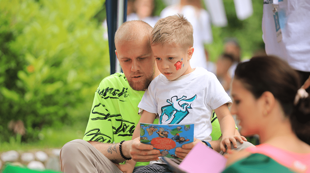 Father reading a book to his son